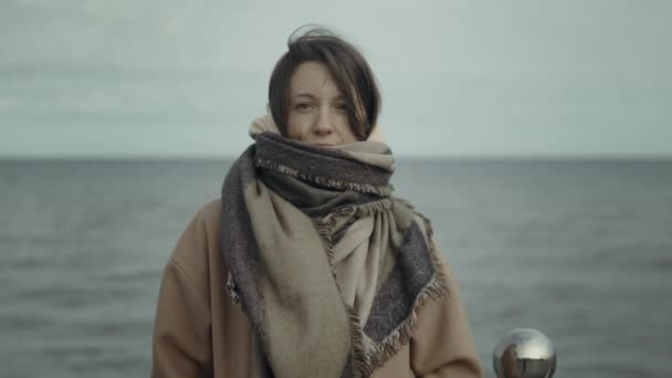 Porträtt av kvinna i varma outwear stående mot havet — Stockvideo