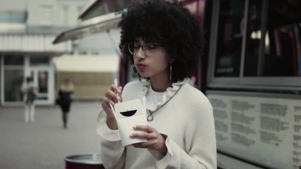 A multiracionális fiatal nő a szabadban ebédel. — Stock videók