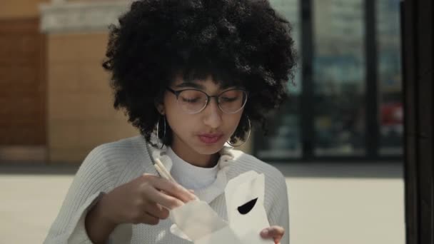 Close up of a black woman eating street food outdoors — Stock Video