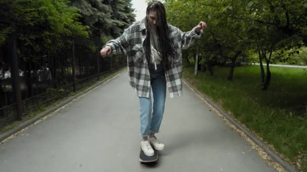 Девочка учится кататься на скейтборде — стоковое видео