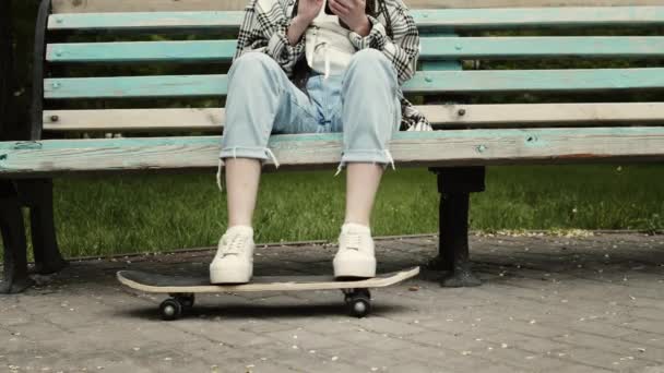 Bastante adolescente chica sentada con monopatín — Vídeos de Stock