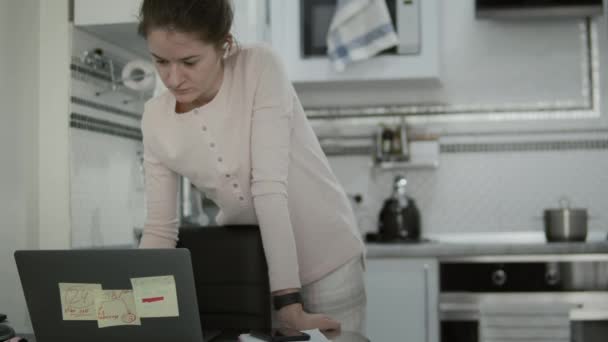 Mujer cocinando la cena durante el trabajo remotamente en casa — Vídeos de Stock