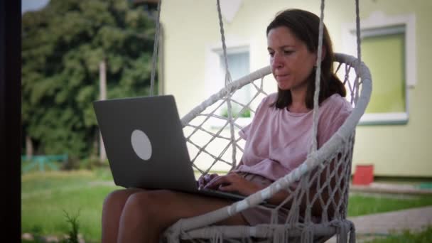 Mulher em cadeira de balanço de jardim — Vídeo de Stock
