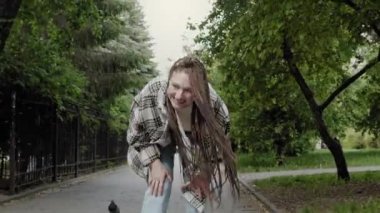 Genç kız kaykay öğreniyor.