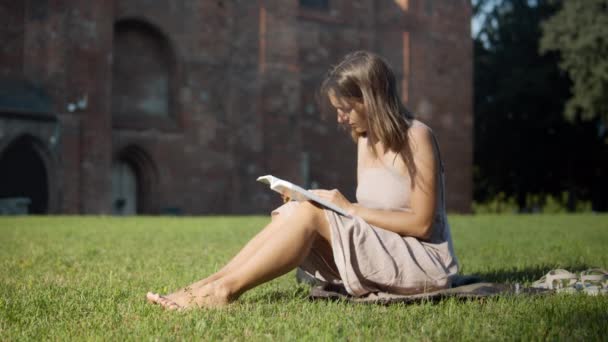 Mujer leyendo un libro cerca del viejo edificio — Vídeo de stock