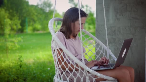 Nő dolgozik a kertben Swing szék — Stock videók
