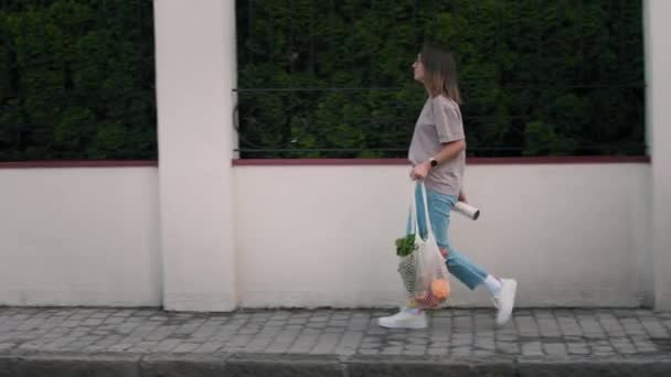Mujer lleva una bolsa ecológica con comestibles — Vídeos de Stock
