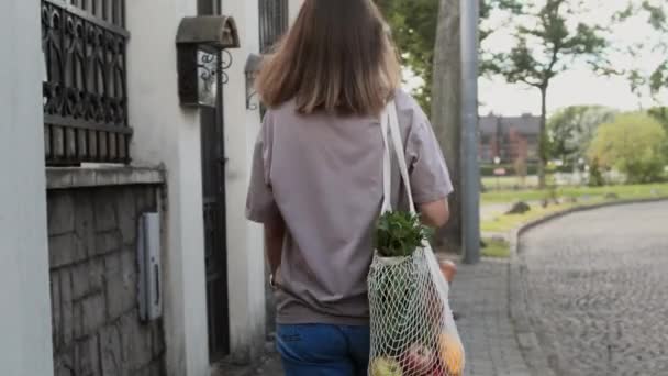 Mladá žena kráčející s ekodesignem na ulici
