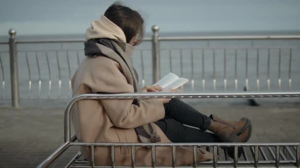 Чтение книги на берегу моря — стоковое видео