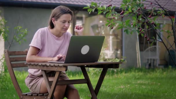 Kobieta pracuje w ogrodzie z laptopem — Wideo stockowe