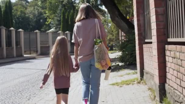 Moeder en dochter lopen na het winkelen — Stockvideo
