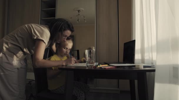 Petite fille faisant ses devoirs avec sa mère à la maison — Video