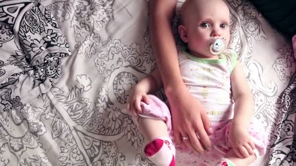Ocho meses niña se acuesta en la cama — Vídeo de stock