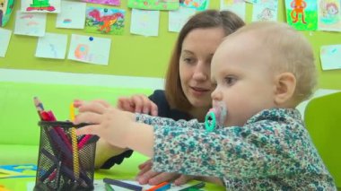 Anne ve küçük bebek çalış ile kalemler