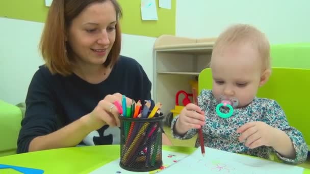 Madre y bebé juegan con lápices — Vídeo de stock