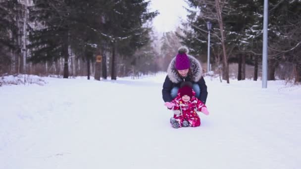 母亲与她的小宝贝女儿在冬季公园走 — 图库视频影像