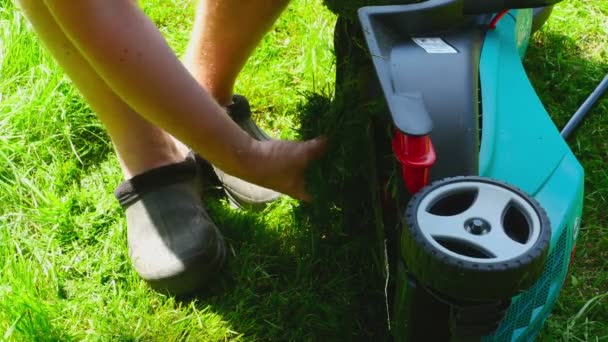 Людина прибирає газонокосарку — стокове відео