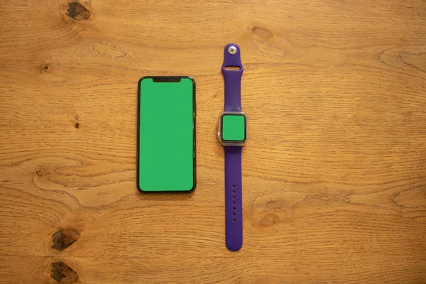 Yeşil ekranlı telefon. Eldeki saat. Akıllı telefonmuş. Modelleme. Yeşil arka plan. Düzen için güzel fotoğraf