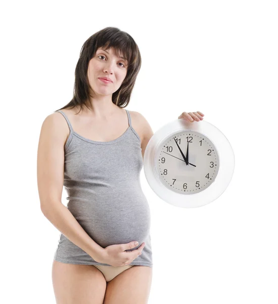 Kobieta w ciąży z zegarem w dłoni — Zdjęcie stockowe