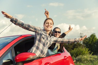 Gün batımında araba kırmızı kızlarda. Seyahat kavramı.