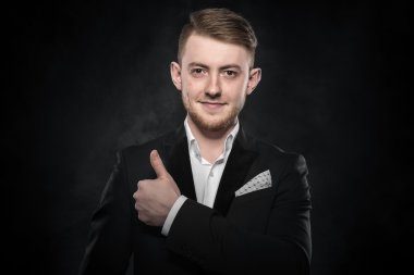 Siyah takım elbiseli genç yakışıklı adam..