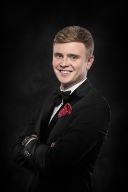 Siyah takım elbiseli genç yakışıklı adam..