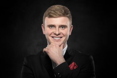 Siyah takım elbiseli genç yakışıklı adam..