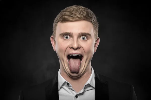 Young businessman with tongue out. — Stock Photo, Image