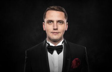 Siyah takım elbiseli genç yakışıklı adam..