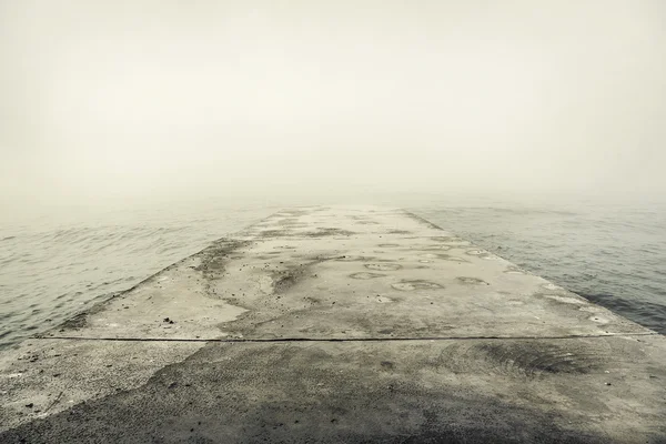 Muelle de piedra en niebla gruesa . —  Fotos de Stock
