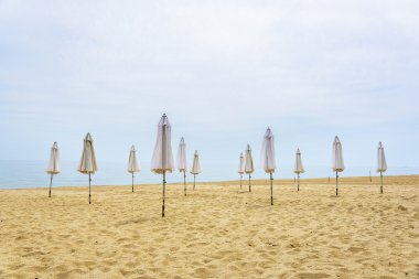 Plajda şemsiye katlanmış.