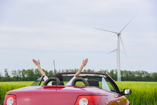 Femme dans un cabriolet rouge dans un champ . — Photo