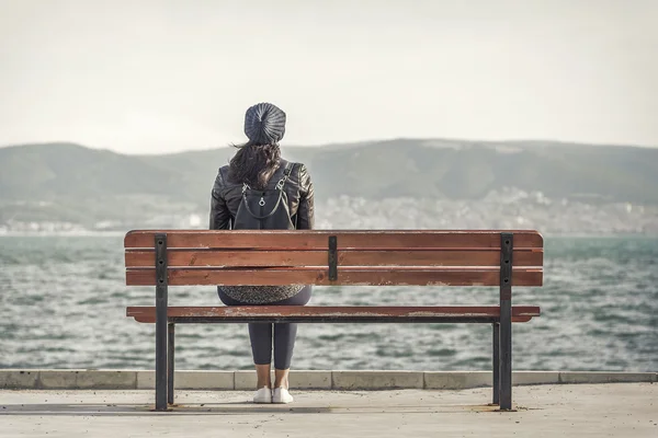 Ragazza sulla panchina vicino al mare . — Foto Stock