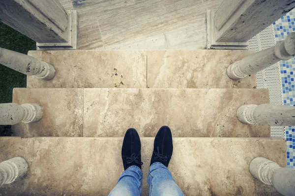 Mens feet on the steps. View from above.