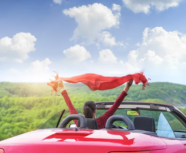 Fille dans une voiture convertible rouge sur fond marin . — Photo