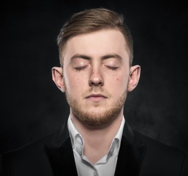 Genç adam bir takım elbise içinde uyur.