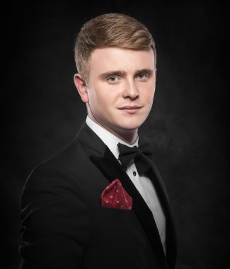 Siyah takım elbiseli genç yakışıklı adam..