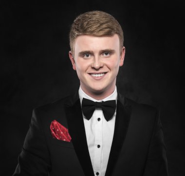 Siyah takım elbiseli genç yakışıklı adam..