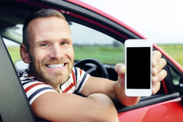 Uomo in auto che mostra smart phone . — Foto Stock