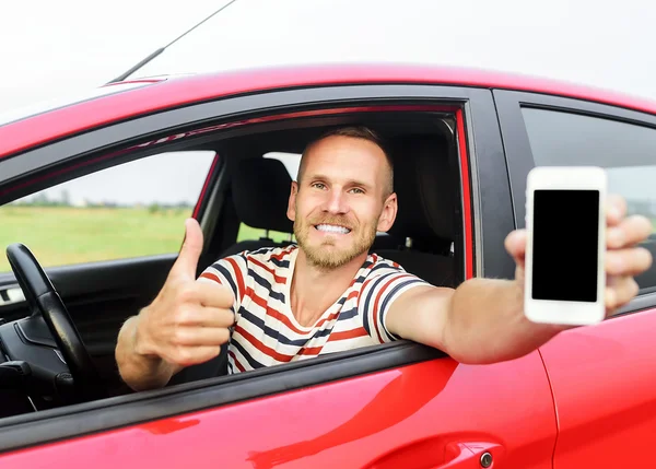 Mann im Auto zeigt Smartphone. — Stockfoto