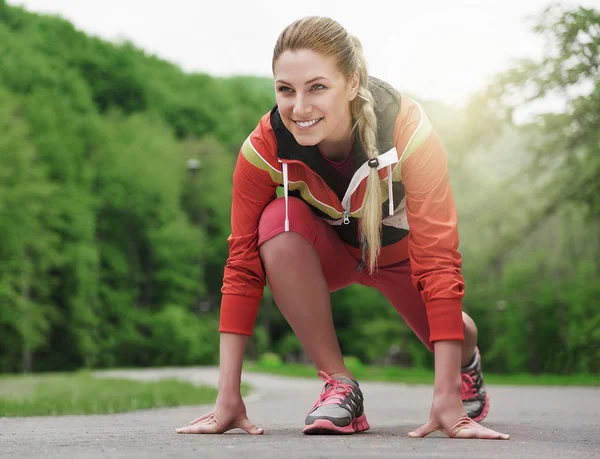 Atractiva mujer rubia corriendo en pista al aire libre . — Foto de Stock