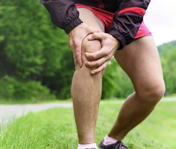 Homme dehors jogging avec douleur au genou — Photo