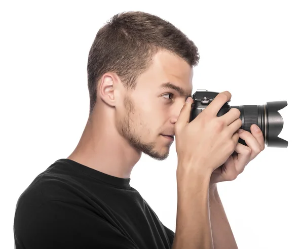 Beau jeune homme tenant un appareil photo reflex numérique . — Photo