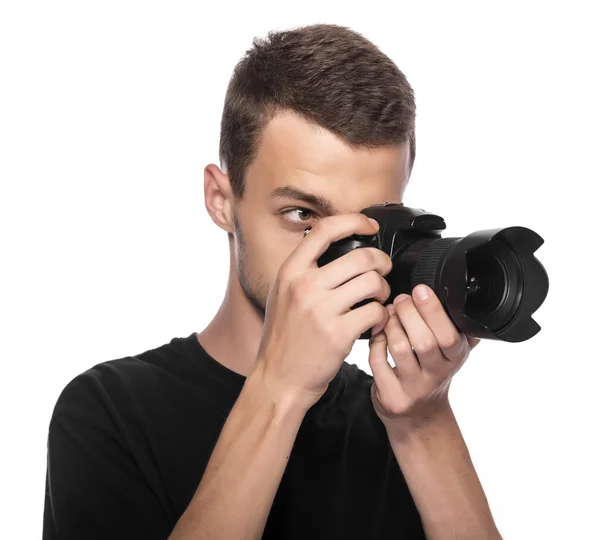 Guapo joven sosteniendo una cámara réflex digital . — Foto de Stock