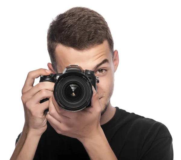 Bello giovane uomo che tiene una fotocamera DSLR . — Foto Stock