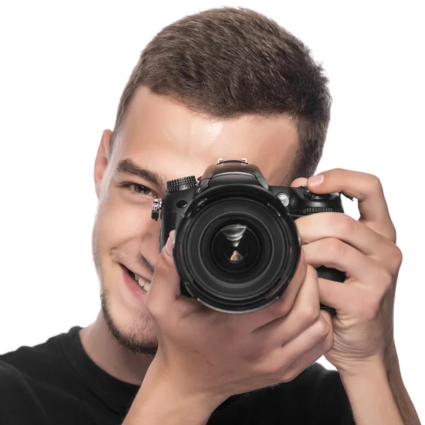 Bello giovane uomo che tiene una fotocamera DSLR . — Foto Stock