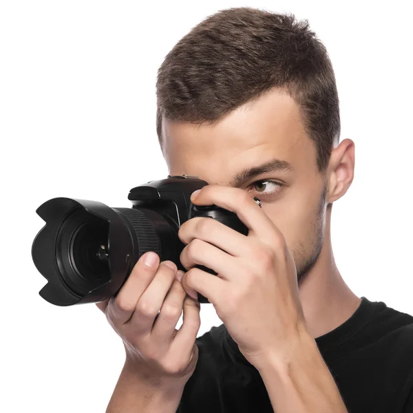 Guapo joven sosteniendo una cámara réflex digital . —  Fotos de Stock