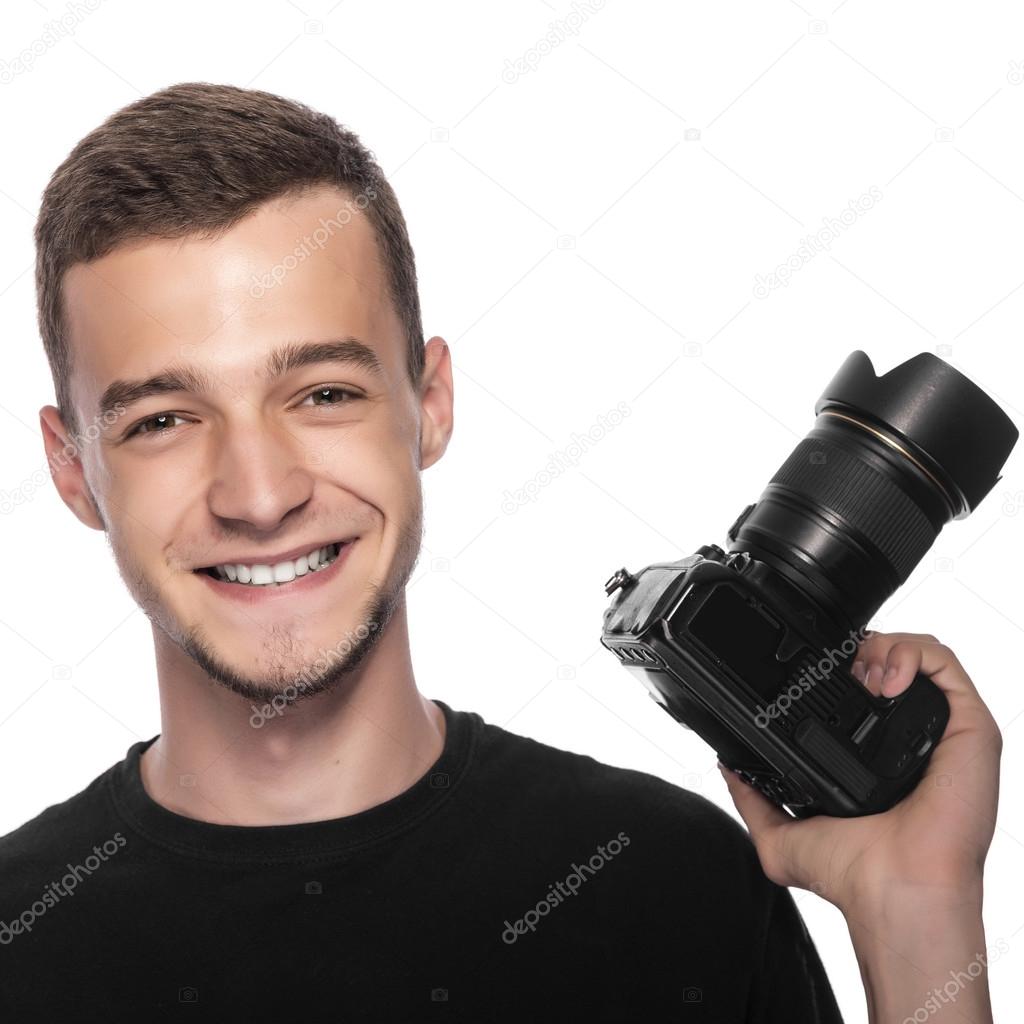 Handsome young man holding a DSLR camera.