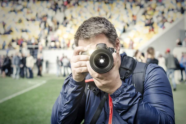 Fotógrafo tira uma foto no estádio . — Fotografia de Stock