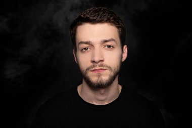 Karanlık bir arka planda genç bir adamın portresi